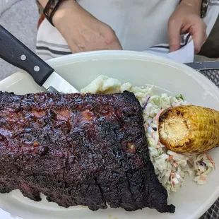 a plate of ribs and coleslaw