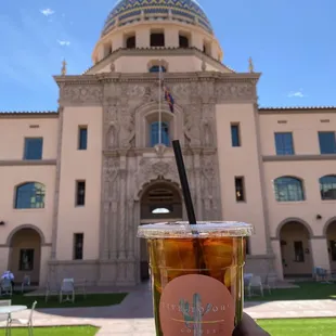 a cup of iced coffee in front of a building