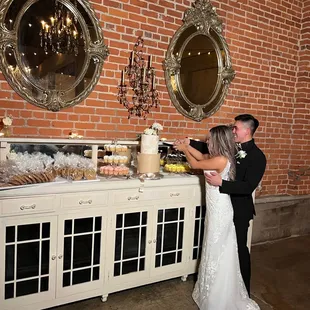a bride and groom cutting their wedding cake