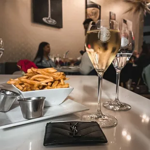a glass of wine and a plate of french fries
