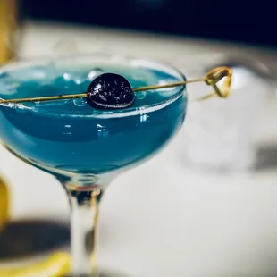 a blue cocktail in a coupe glass