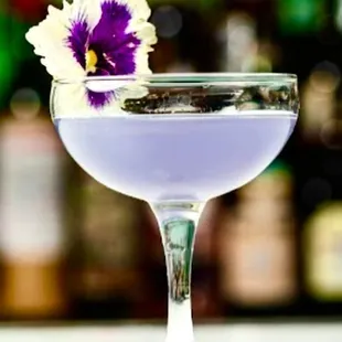 a purple cocktail with a flower in it