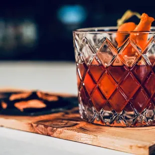 a drink in a glass on a cutting board