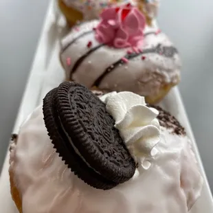 a row of doughnuts with frosting and sprinkles