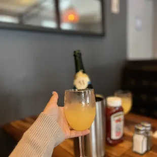 a person holding a glass of orange juice