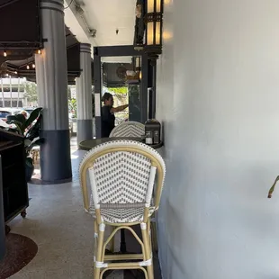 a wicker chair in front of a white wall