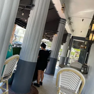 a woman in a black dress standing in the doorway of a restaurant