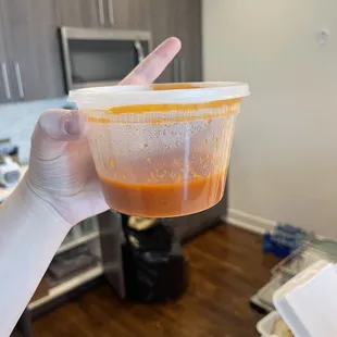 a person holding a bowl of sauce