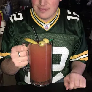 a man in a green jersey holding a drink