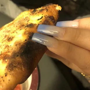 a hand holding a piece of pizza