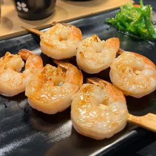 shrimp skewers on a black plate