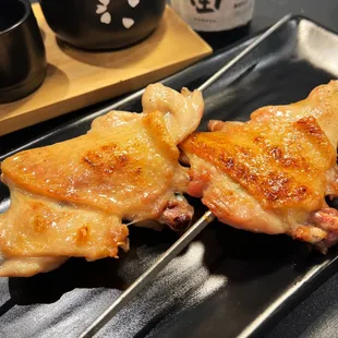 two pieces of chicken on a black plate