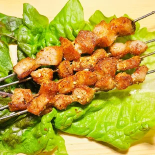 skewered chicken and lettuce on a bed of lettuce
