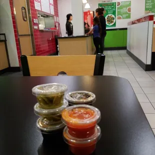 a table with three containers of sauce