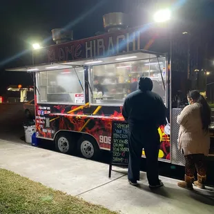 a man and woman ordering food from a food truck