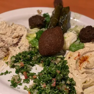 It is called Mazza has a little of everything hummus baba guan pigs grape leaves tabbouli kibbeh and falafel a must try dish