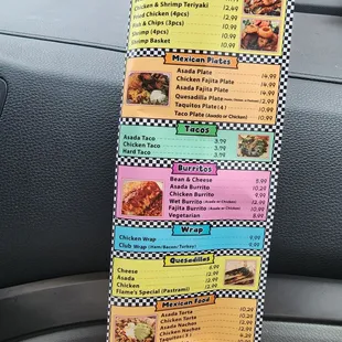 a hand holding a menu in a car