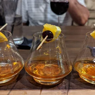 three glasses of whiskey with a garnish