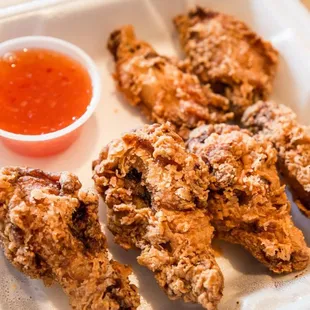 a tray of fried chicken with dipping sauce