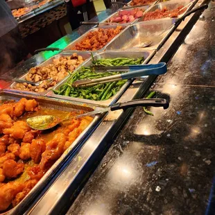 a variety of food being served at a buffet