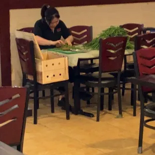 A lady snapping the fresh green beans. Very nice.