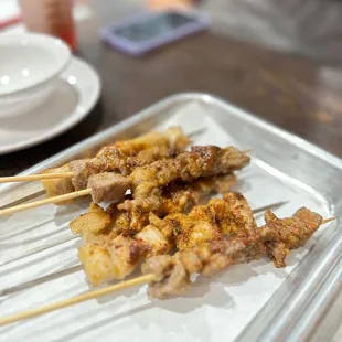 skewered meat on a tray on a table