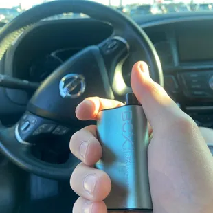 a hand holding a lighter in a car