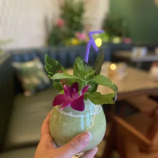 a person holding a drink in a restaurant