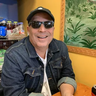 a man wearing sunglasses and a denim jacket