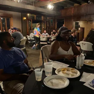 a group of people sitting at a table with plates of food