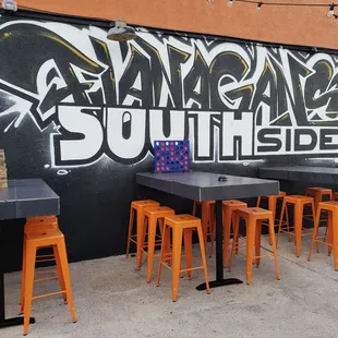 tables and chairs in front of a mural