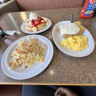 Country fried steak, strawberry pancakes, hash brown and scrambled eggs