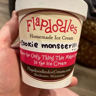 a hand holding a cup of ice cream