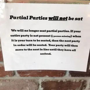 a sign posted on a brick wall