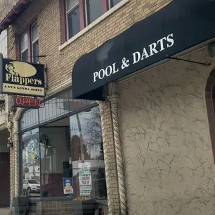 a brick building with a sign for pool and darts