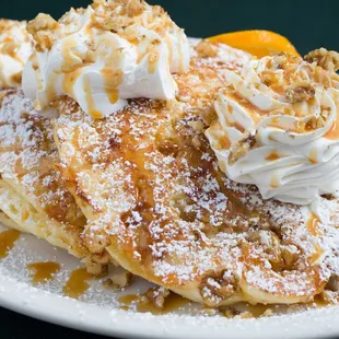 a stack of pancakes topped with whipped cream