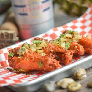 a plate of wings with a side of beer