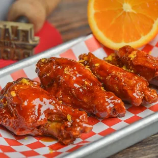 a tray of wings and orange slices