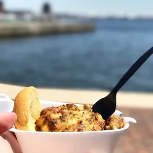 a hand holding a fork and a bowl of food