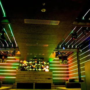 a dimly lit bar with neon lights