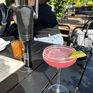 a pink drink with a lime wedge