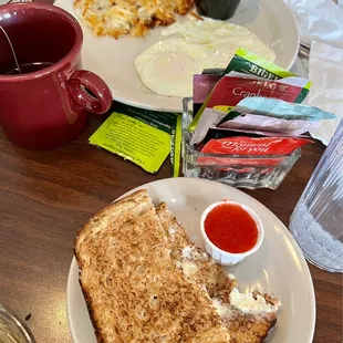 Eggs with hash browns and avocado, toast jam and tea