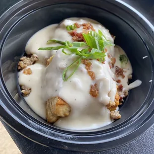 Biscuits and gravy with sausage and bacon bits and green onions