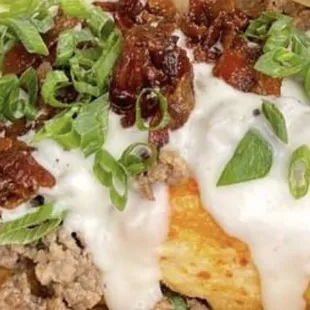 We ladle on country gravy and breakfast finish it with sausage, candied bacon jam and a sprinkling of chopped green onions.