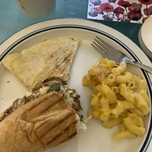 Mac and cheese , half steak sandwich and half quesadilla