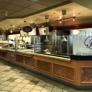 a woman walking past a counter in a restaurant