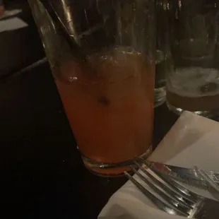 a glass of orange juice and a fork