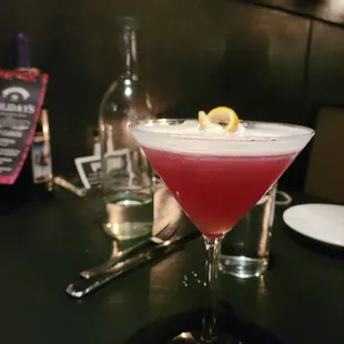 a red cocktail in a martini glass
