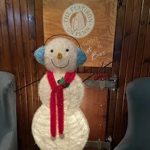a snowman with headphones and a red scarf