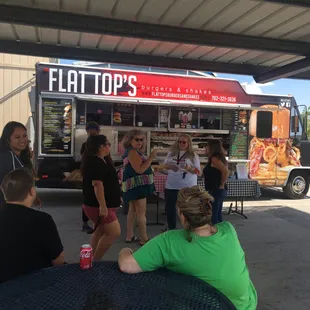 a group of people standing around a food truck